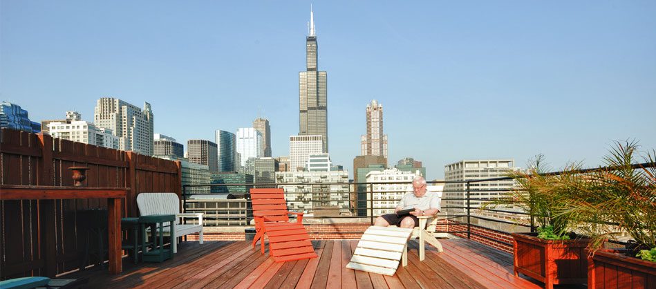Man sitting on a chair with city buildings in the horizon